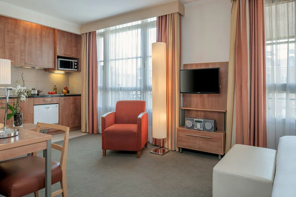 Kuchyň, stůl a místo k sezení u okna ve studiu Citadines Saint-Germain-des-Prés